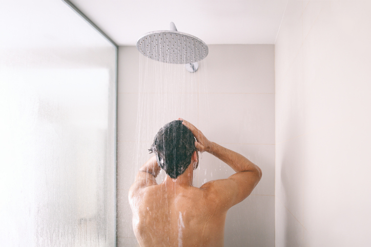  |  Man taking a shower washing hair with shampoo product under water falling from luxury rain shower head. Morning routine luxury hotel lifestyle guy showering. body care hygiene
