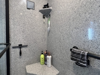 Classic black frame shower, different size shelves, grey wall