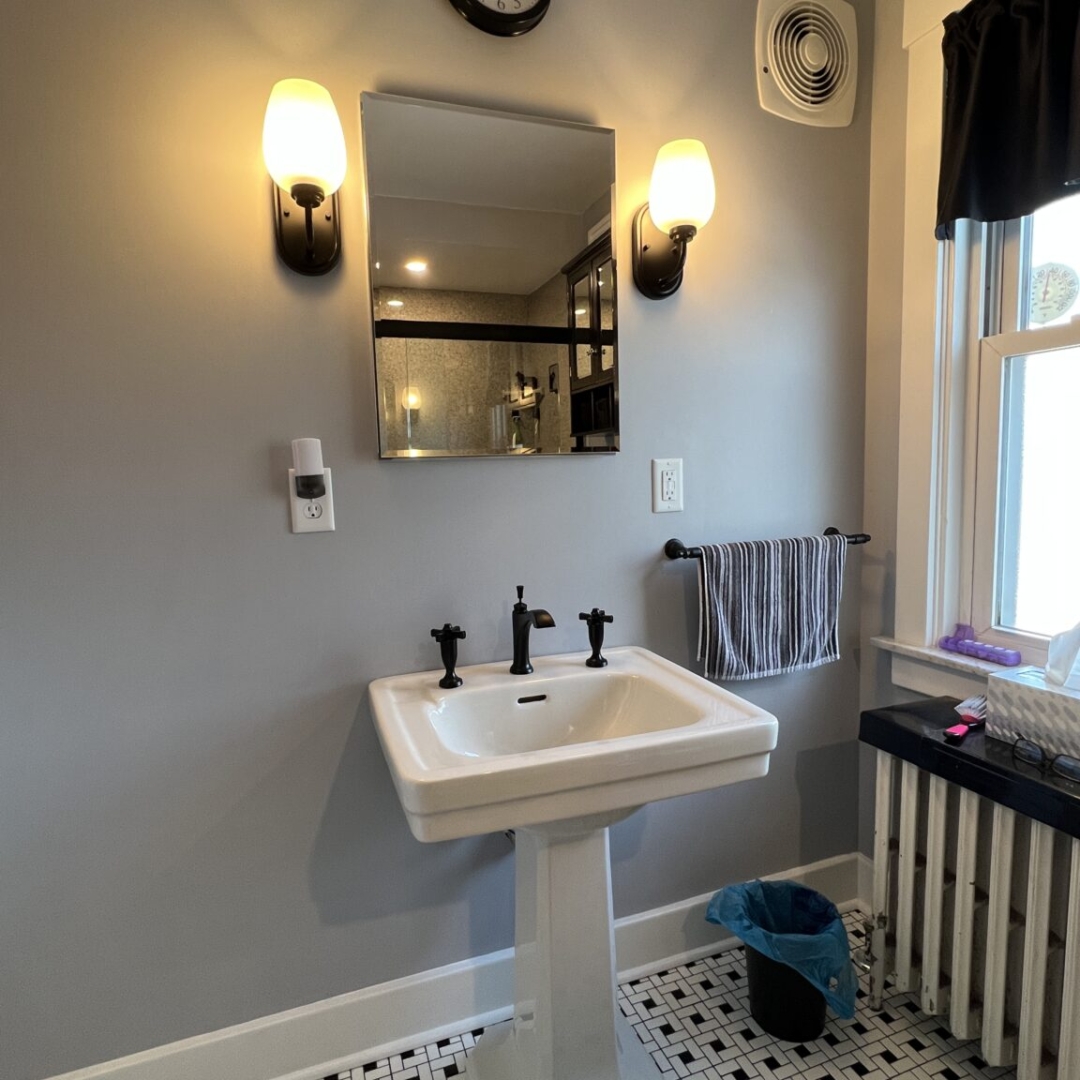 Traditional bathroom remodel, simple white sink, black and white floor tiles, window