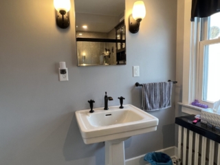 Traditional bathroom remodel, simple white sink, black and white floor tiles, window
