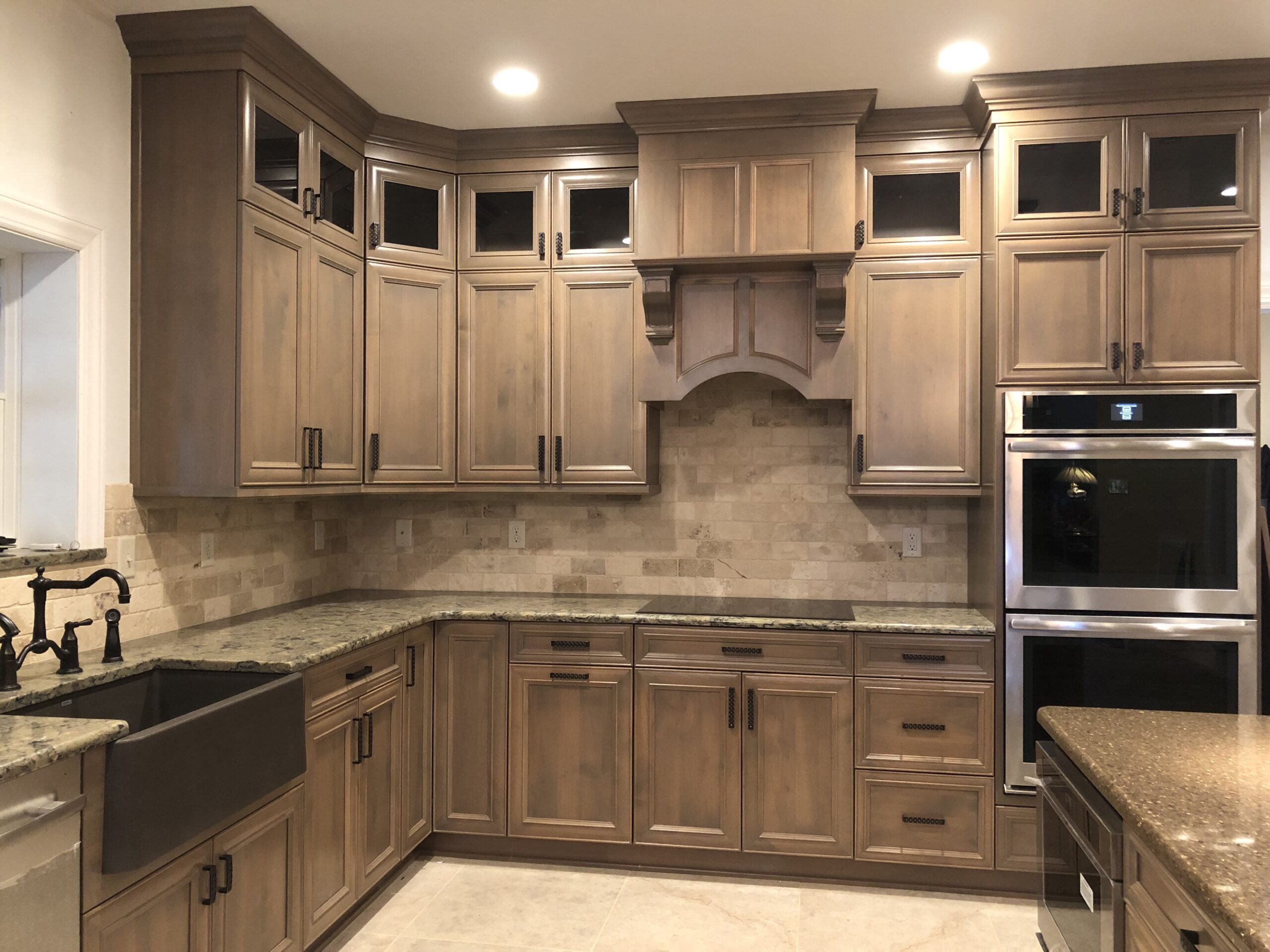 Traditional brown kitchen, traditional wooden furniture storage, marble counter, two ovens