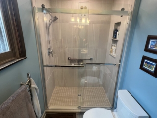 Classic blue bathroom remodeling, light gray shower tile walls, small beige square tile floor, two piece toilet toilet