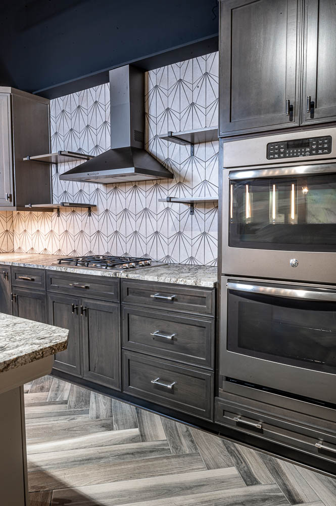 Contemporary kitchen remodeling, original designed backsplash, grey cabinets, vent hood black stove