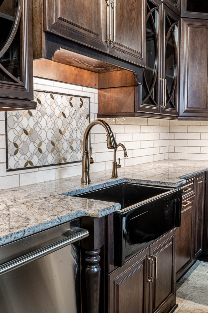 Traditional kitchen remodel, farming sink, white tile backsplash, traditional brown cabinets, marble counter