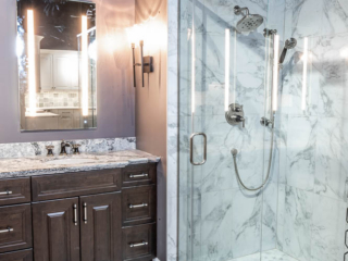 Classic bathroom, double sink with black and white marble top and dark cabinets, shower with large grey wall tiles, modern black and white tile floor