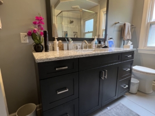 Contemporary bathroom, white marble countertop sink, black cabinet storage, one-piece toilet, blurry window