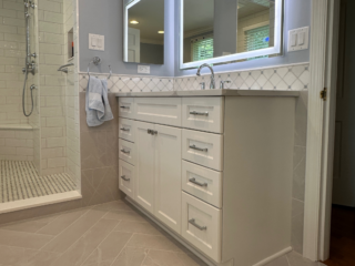 Classic small blue bathroom remodel with sink and open shower and black and white shower tiles, modern brown floor tiles