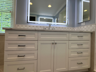 Classic small blue bathroom remodel with sink, white cabinet storage, large lighting mirror