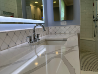 Classic blue bathroom remodel with white marble single sink and storage