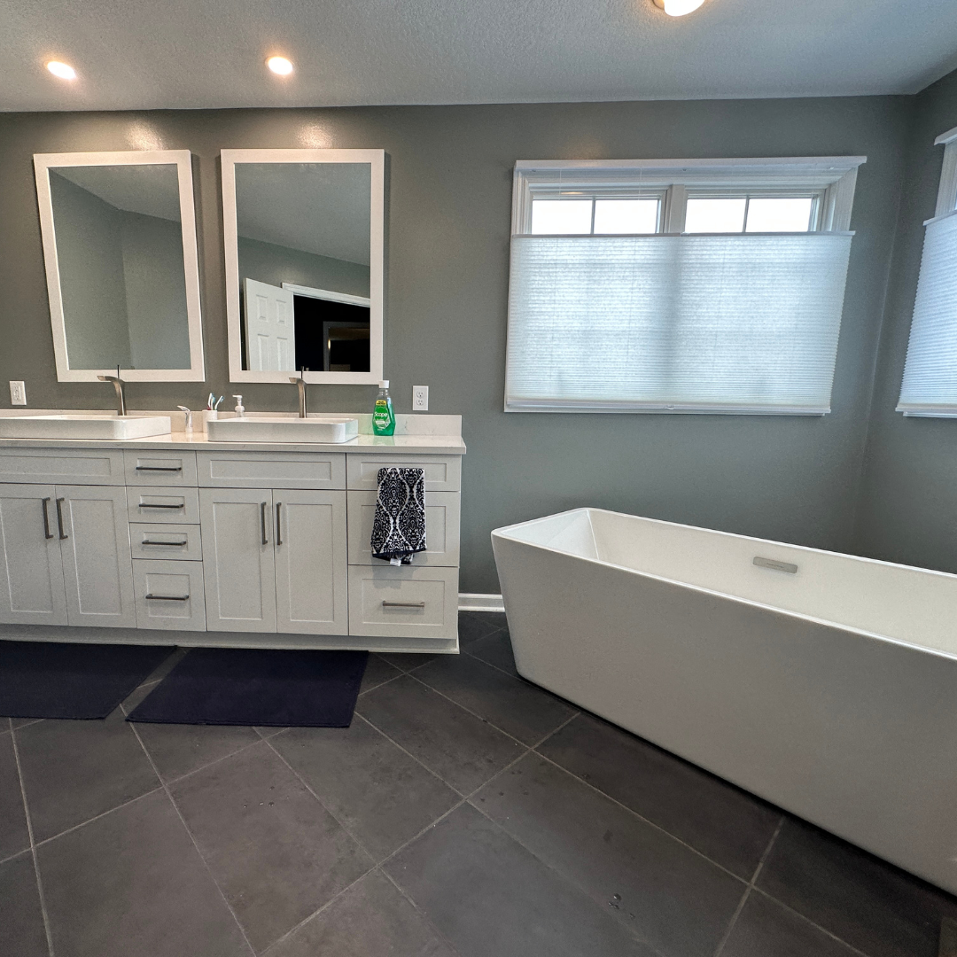 Contemporary bathroom remodel, expansive bath tub and 2 sinks with white marble countertop, white cabinets modern grey floor tile
