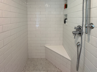 Classic bathroom remodel with black and white shower tiles and white wall tiles