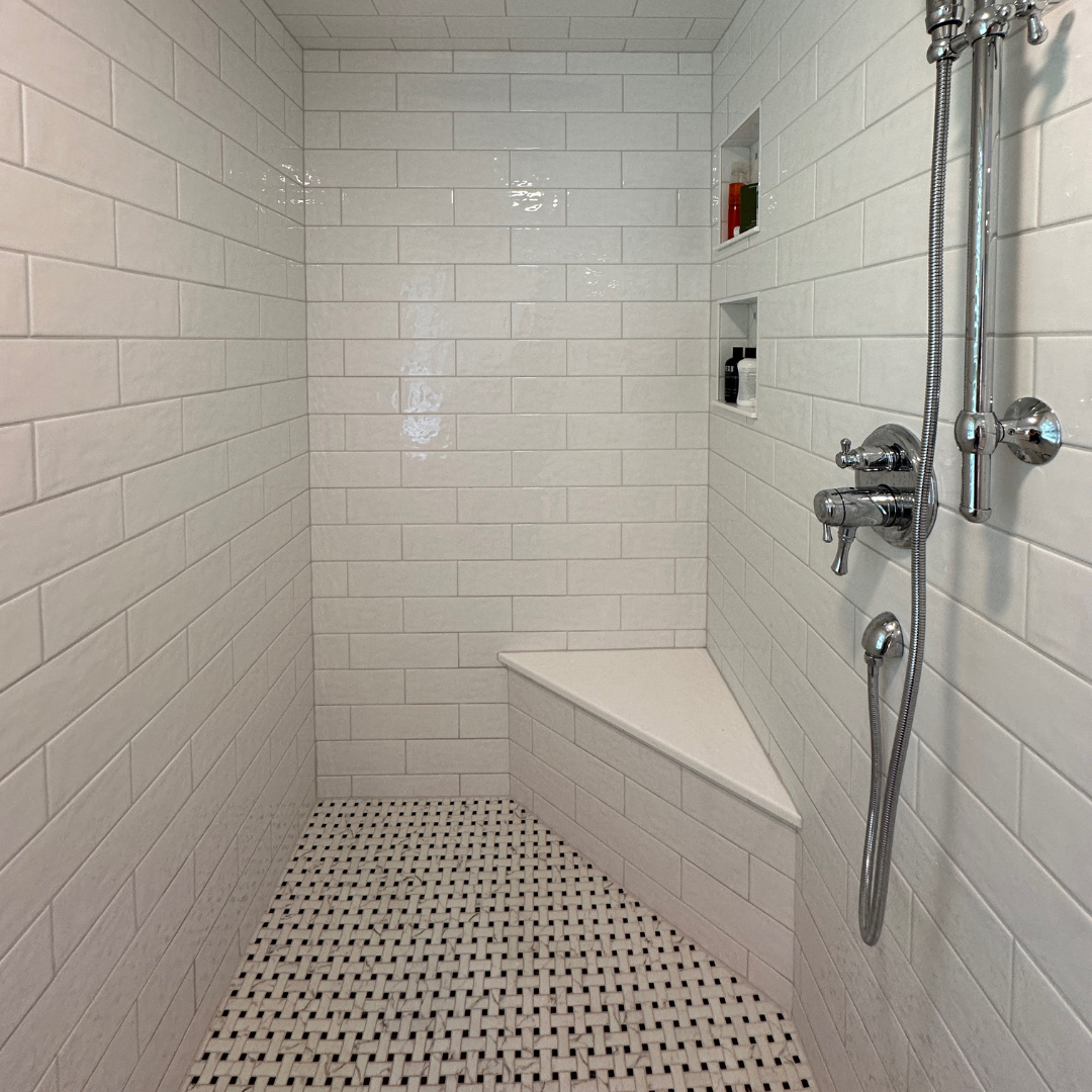 Classic bathroom remodel with black and white shower tiles and white wall tiles