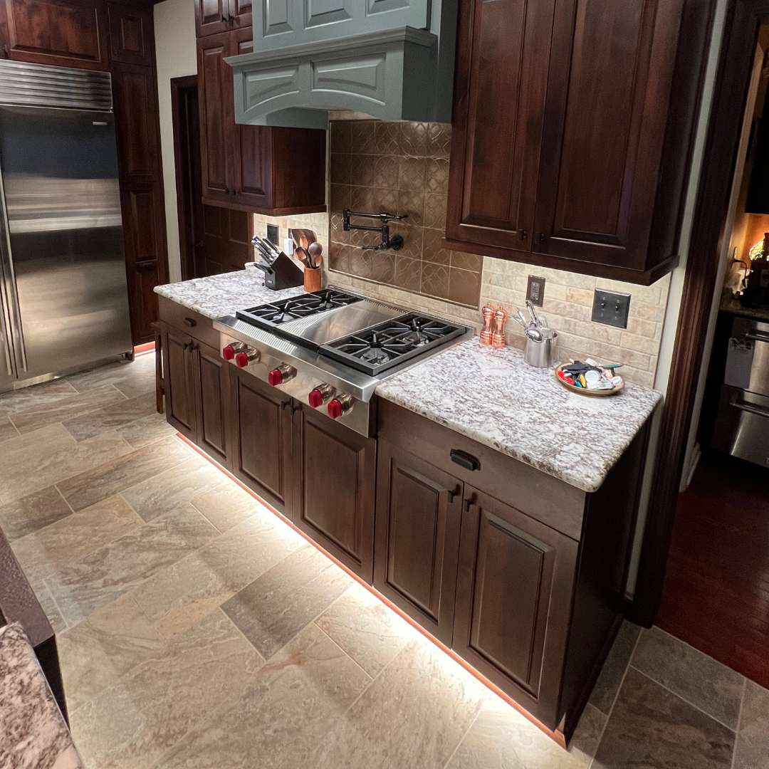 Traditional kitchen remodel with floor lightings, marble countertops, dark brown cabinet storage and traditional dark backsplash