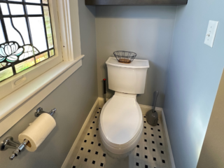 Traditional small bathroom remodel with classic two-piece toilet, Black and white squared floor tiles, window
