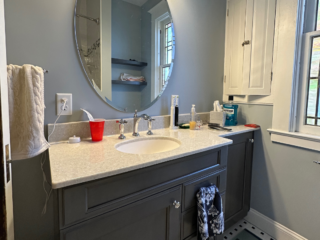 Traditional small bathroom remodel with small modern single sink, marble countertop sink, dark cabinets
