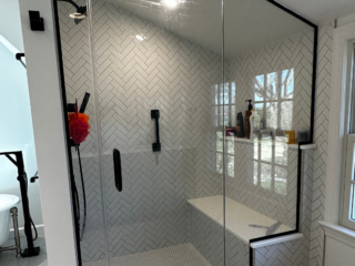 Contemporary bathroom remodel with black frame, and black and white shower tiles