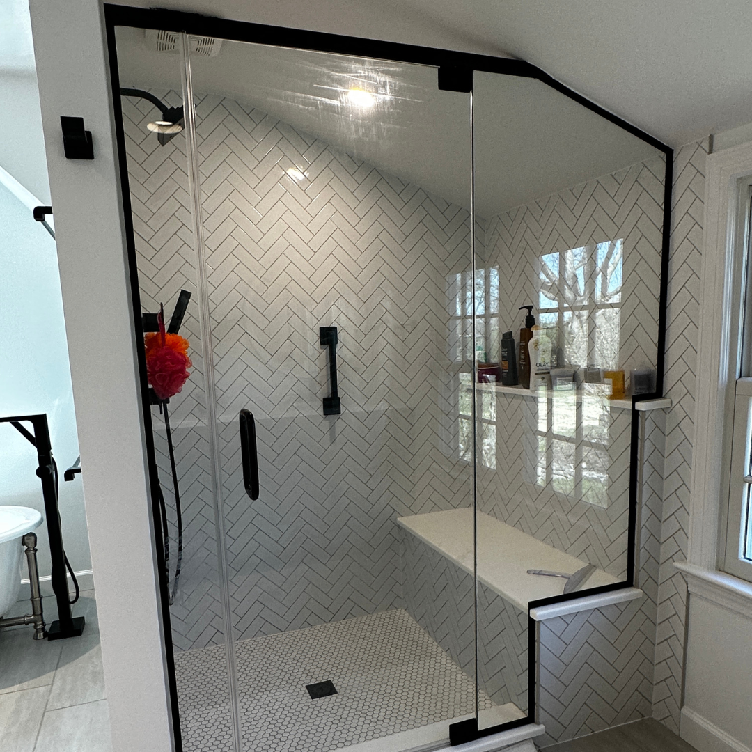 Contemporary bathroom remodel with black frame, and black and white shower tiles