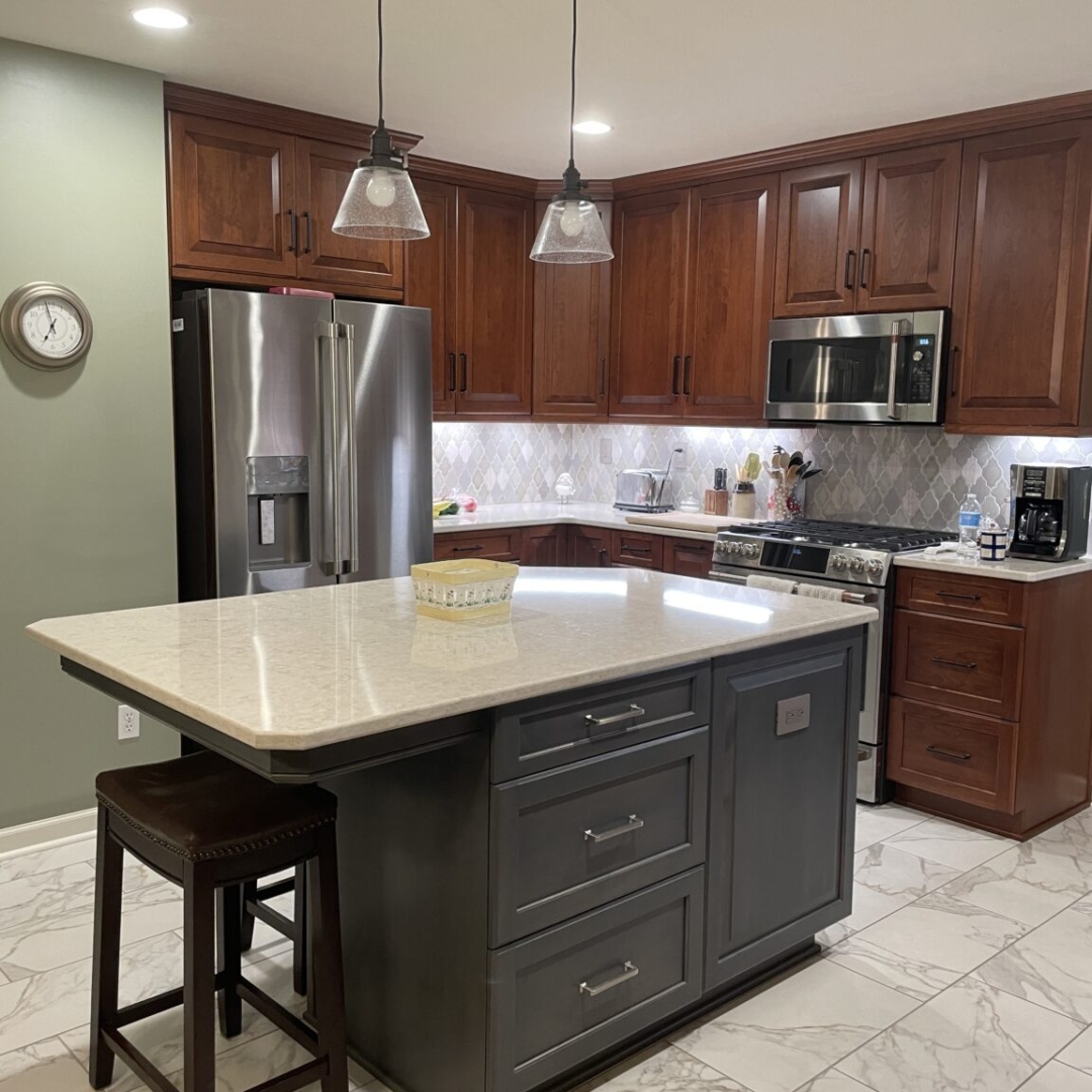 Classic kitchen, center island with white marble countertop, dark island drawers, brown cabinets and storage, arabesque tile backsplash, black and white floor tiles, light green wall