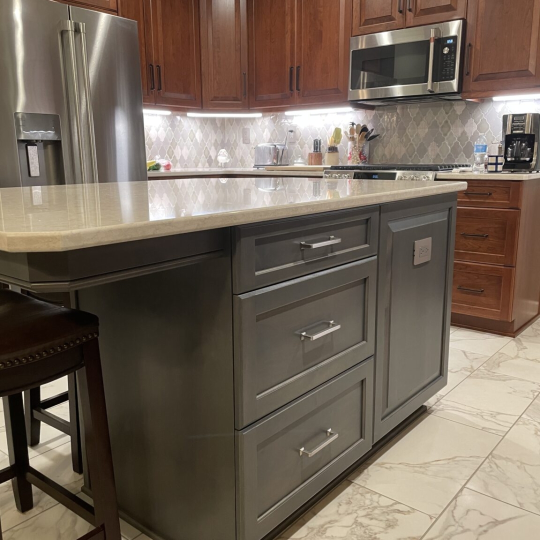 Classic kitchen, center island with white marble countertop, dark island drawers, brown cabinets and storage, arabesque tile backsplash, black and white floor tiles