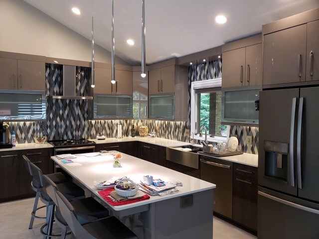 Modern brown kitchen, brown wall cabinets, center island, white marble countertops, arabesque colorful backsplash, light brown floor tiles, black stove