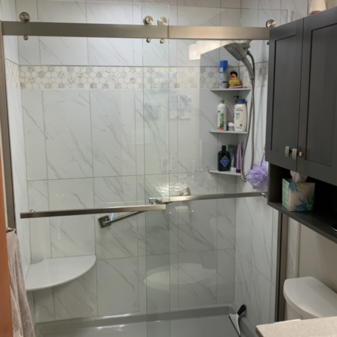 Classic small bathroom remodel, white marble tile shower walls, shower shelves, toilet