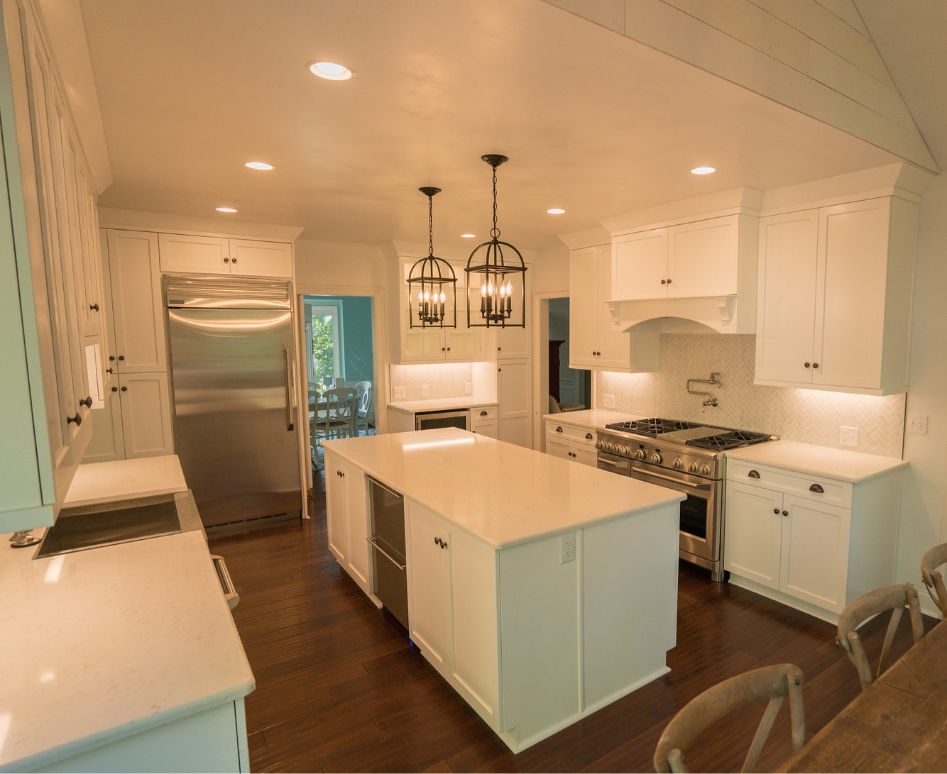 Classic whit kitchen, white wall and base cabinets, white countertop island, brown floor tiles