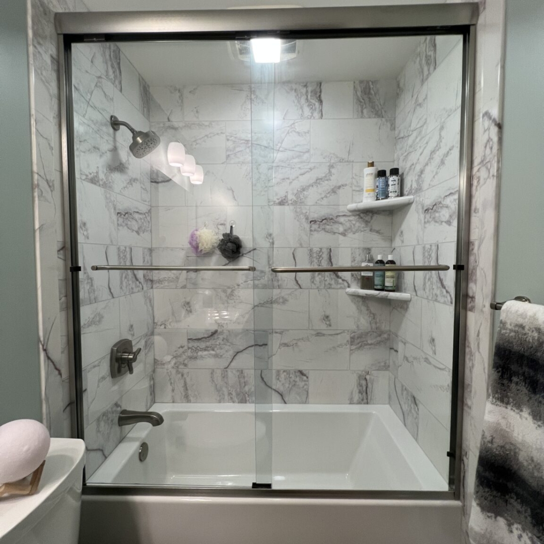 Modern bathroom, black and white marble walls, small shelves, shower head, bathtub
