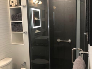Contemporary bathroom, black tiles, shelves, toilet