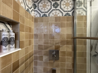 Terracotta square bathroom tiles, shower with storage, modern rainfall shower head, contemporary bathtub and shower