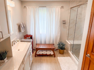 Classic bathroom, large cabinet storage, marble shower, light brown modern floor tiles, big window