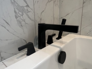 Black faucet inspiration, luxury bath detail, spa-like faucet design, contemporary tub idea, marble wall inspiration, elegant bath feature