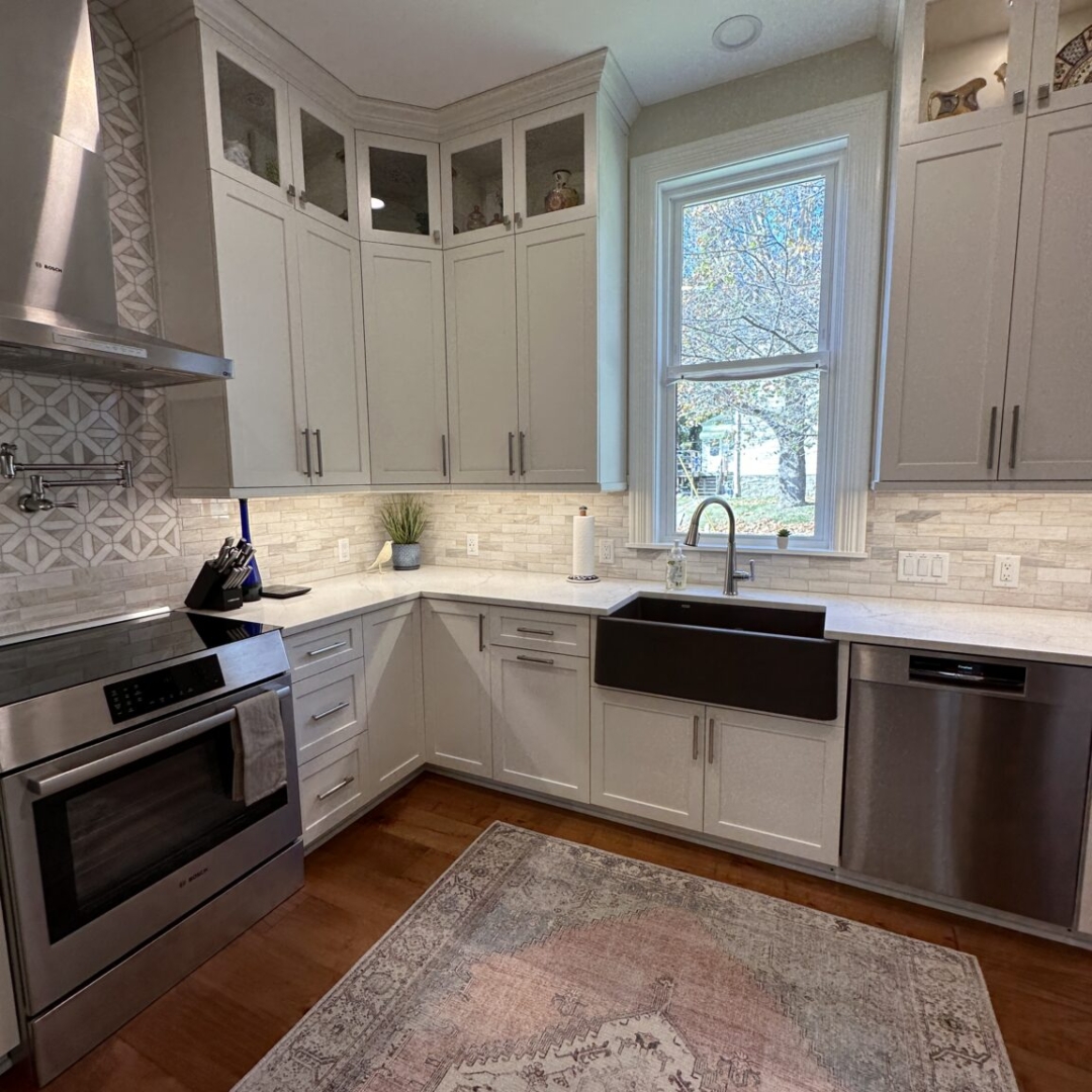 Classic white kitchen counter and stove, white wall and base cabinets, modern white tile backsplash, brown tile floor