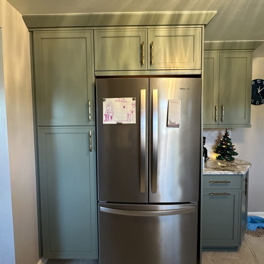 Modern kitchen remodel fridge, green base cabinets, beige rectangular floor tiles