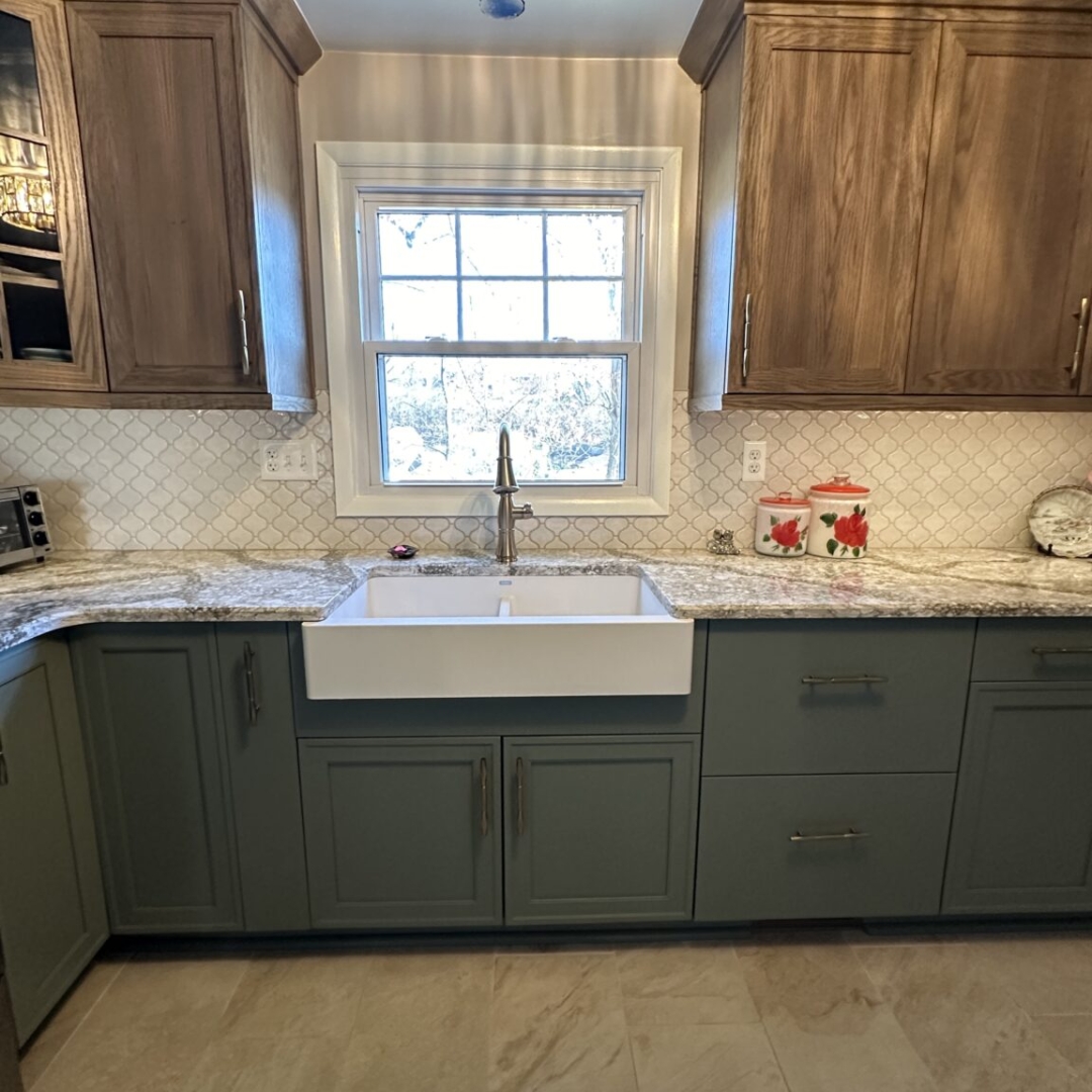 Modern kitchen remodel, dark green base cabinets, brown wall cabinets, grey and white countertop, farming sink, beige rectangular floor tiles