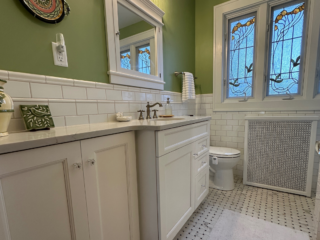Traditional bathroom, white marble countertop single sink, top mirror cabinet, bottom white cabinet, light green walls, original white and grey floor tiles