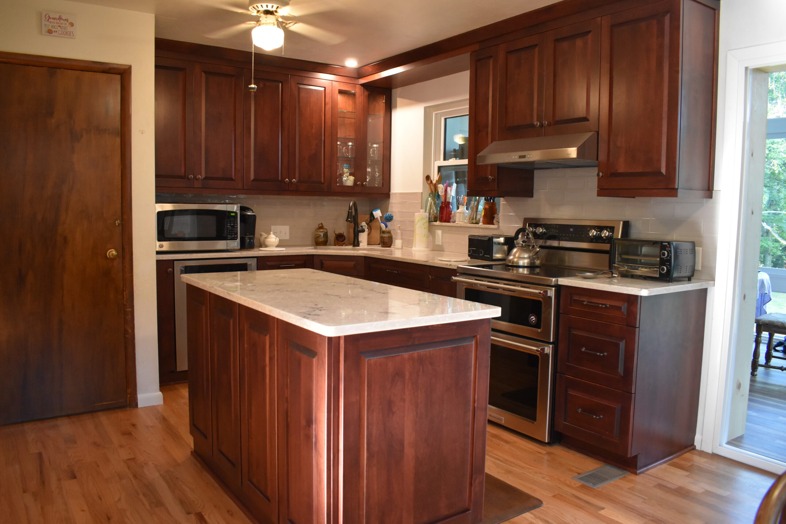 Classic brown wooden island with white marble countertop, brown cabinet storage, white marble counter