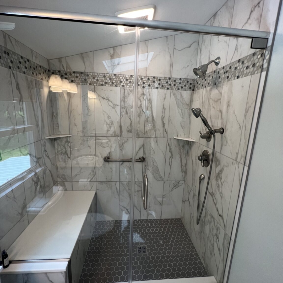 Classic bathroom, black and white marble shoer walls, dark shower floor tiles, shelves, grey shaded marble band