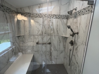Classic bathroom, black and white marble shoer walls, dark shower floor tiles, shelves, grey shaded marble band