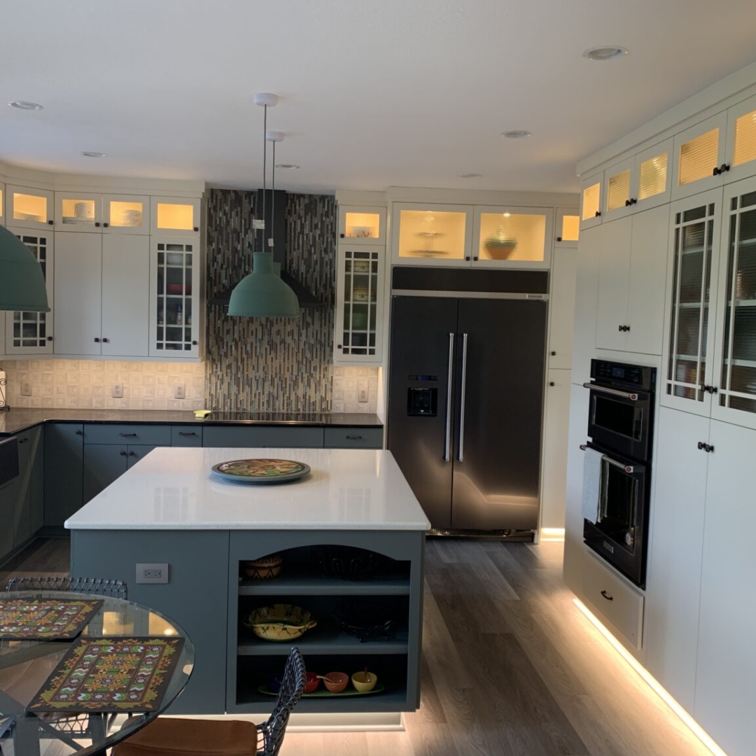 Modern blue kitchen remodeling, square island with storage and white marble countertop, black marble counter, blue base cabinets, white closet storage, black and white tile backsplash, island and cabinet floor lighting