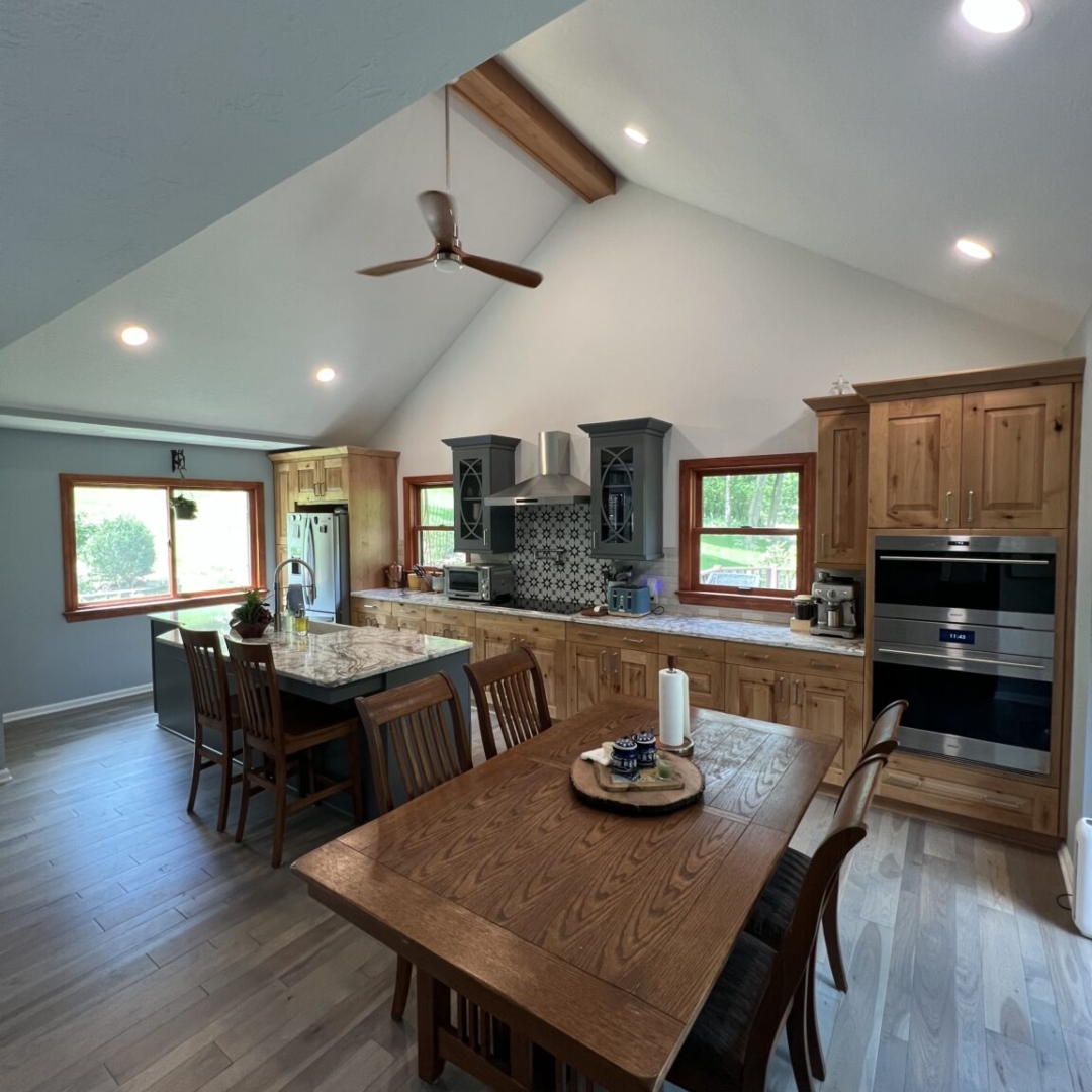 Rustic kitchen inspiration. open-concept kitchen idea, vaulted ceiling kitchen design, wooden dining table decor, kitchen island with seating