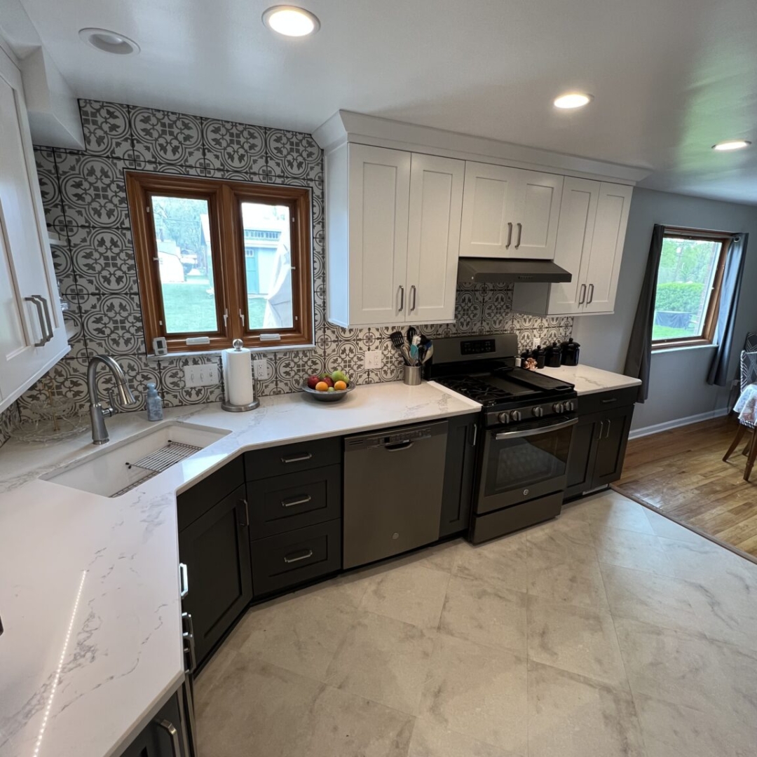 Modern black and white kitchen, white wall cabinets, black base cabinets, white marble countertops, backsplash arabesque design