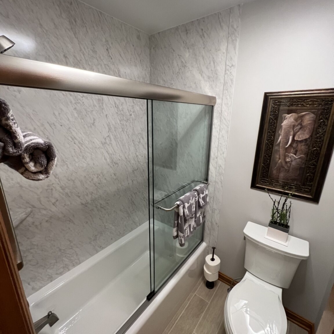 Classic bathroom, white marble shower walls, tub, toilet