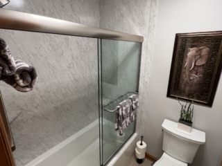 Classic bathroom, white marble shower walls, tub, toilet